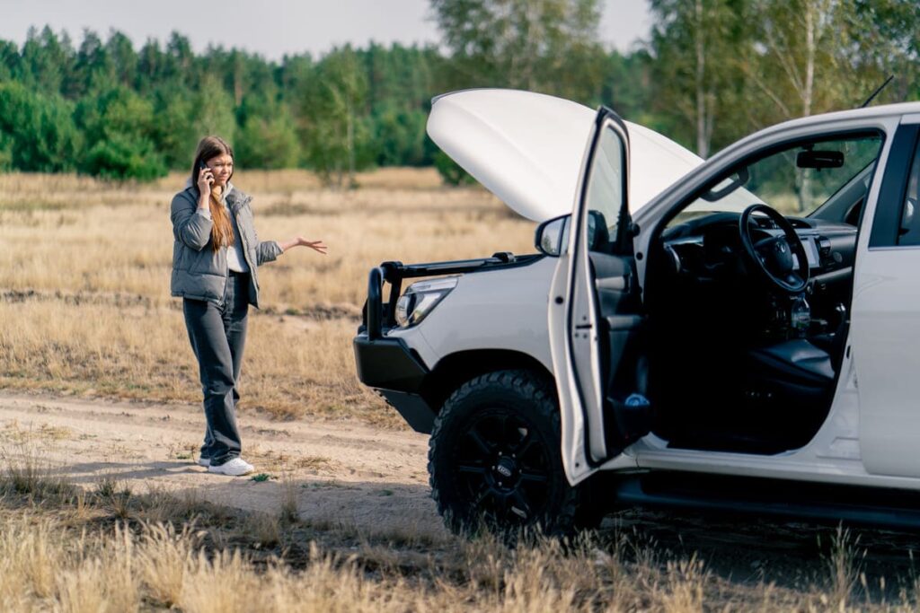 the-car-broke-down-on-road-in-forest-and-young-gir-QRUJQVX-1024x683